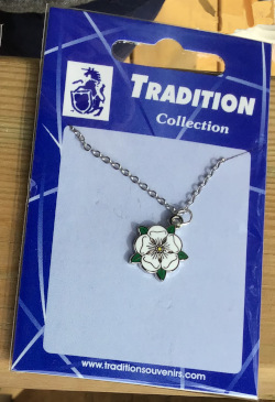 White rose necklace displayed on cardboard
