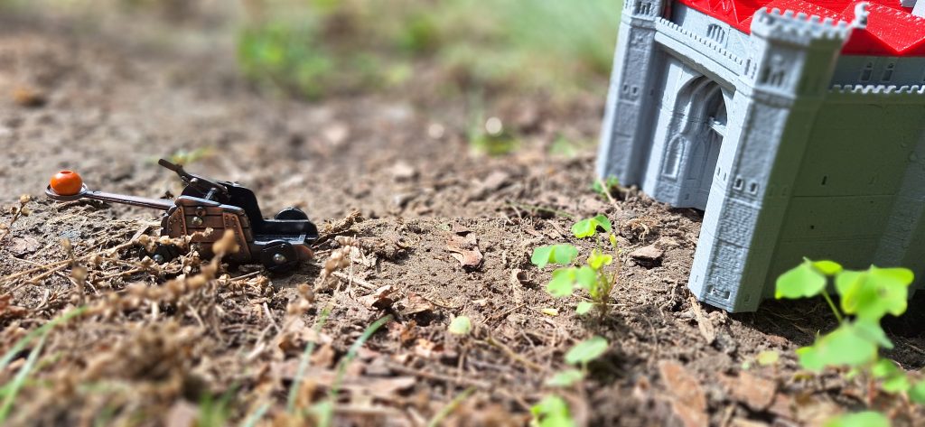 catapult on grass in front of a toy castle